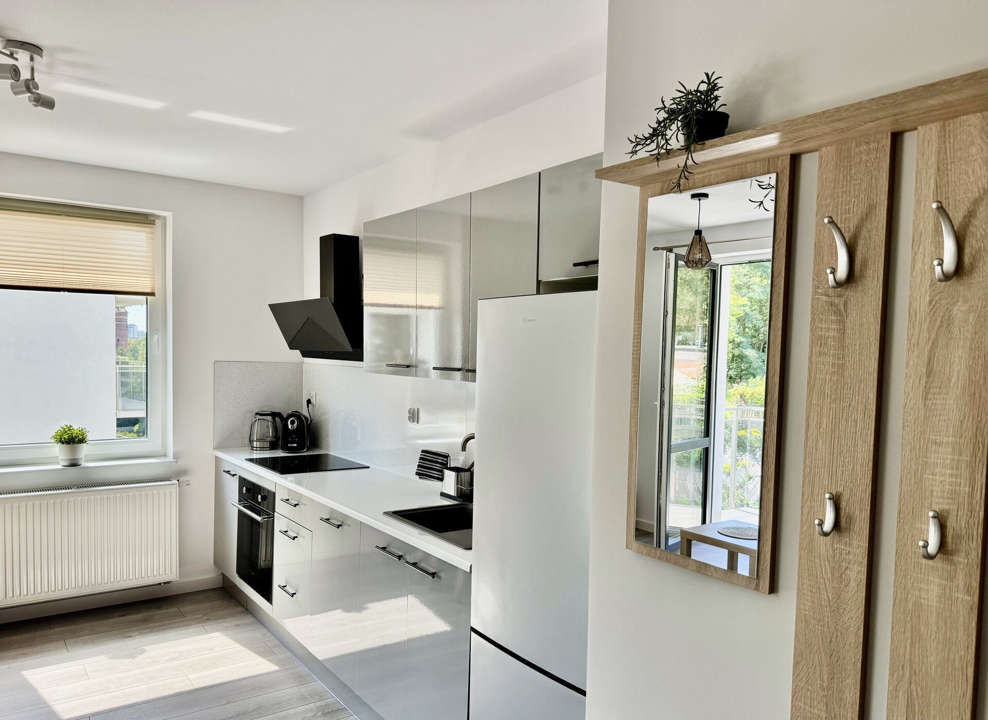 Kuchnia z wejściem i lustrem — apartament Olsztyn